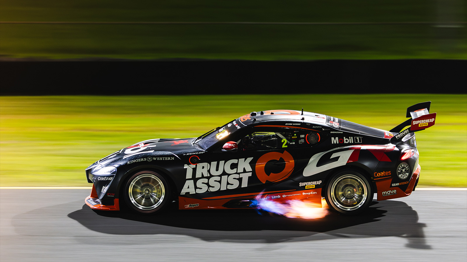 Ryan Wood’s Toyota Supra shooting flames at night.